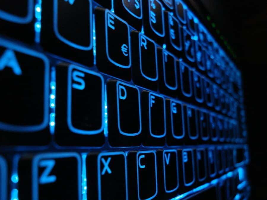 sleek illuminated gaming keyboard with vibrant blue glow against a dark background.