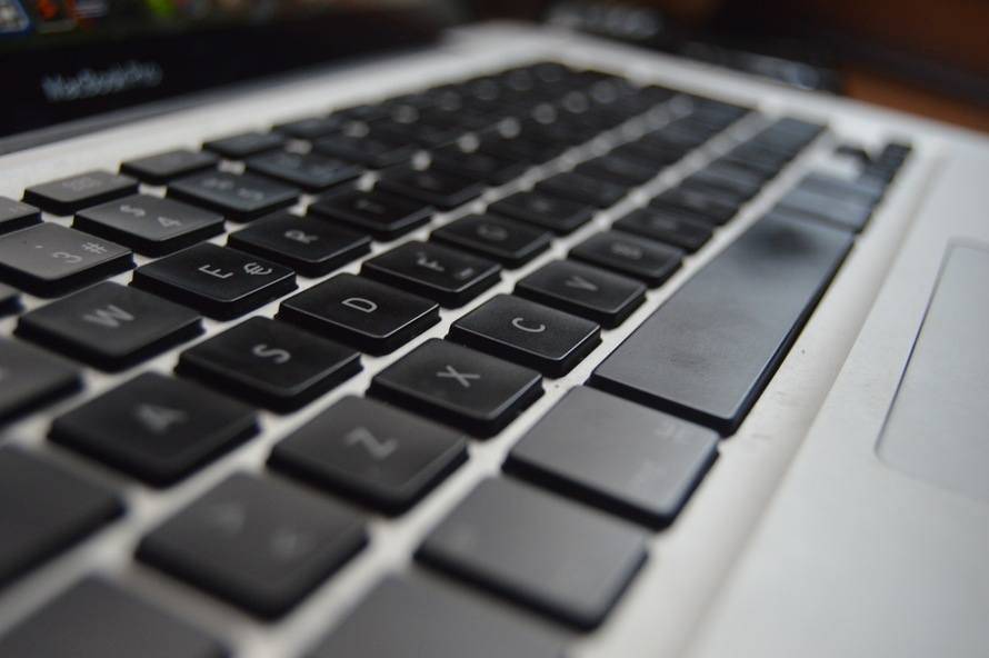 Close-up of a sleek black laptop keyboard highlighting essential productivity shortcuts.