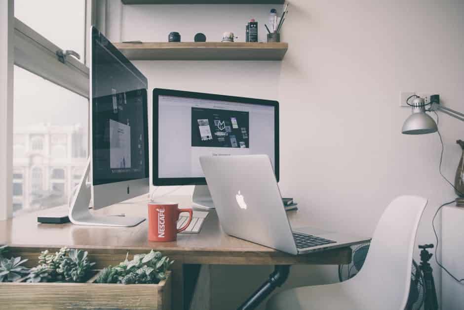 Cozy minimalist workspace with a light wood desk, plants, and natural light for creativity.