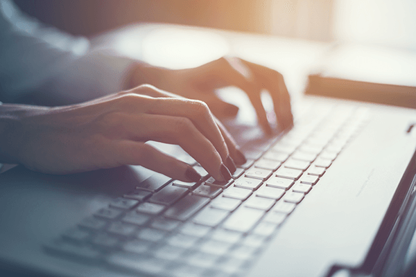 Close-up of hands on a laptop, highlighting keyboard shortcuts for time-saving in Chrome.