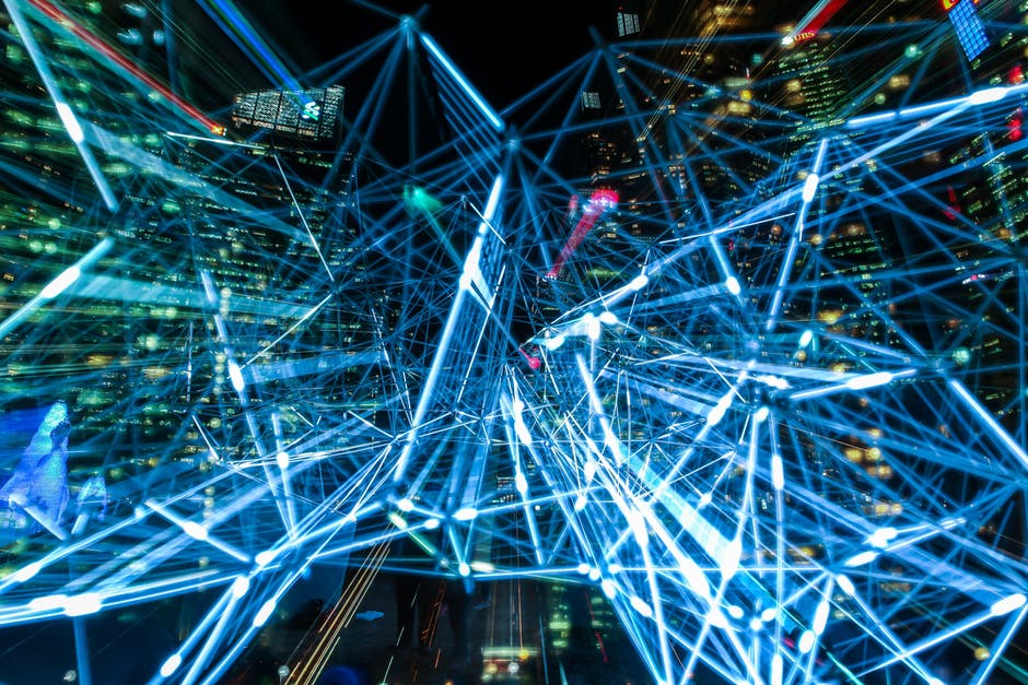 Vibrant blue network lines symbolize digital connectivity amid an illuminated urban landscape.