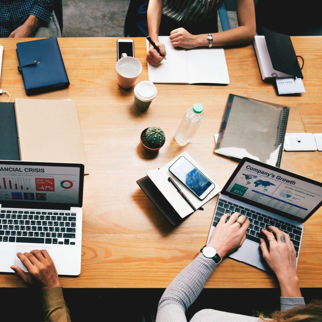 dynamic workspace for strategic business discussions with laptops, notes, and a touch of greenery.