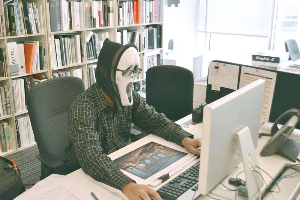 casual office worker in a horror mask, merging creativity and humor in a professional setting.