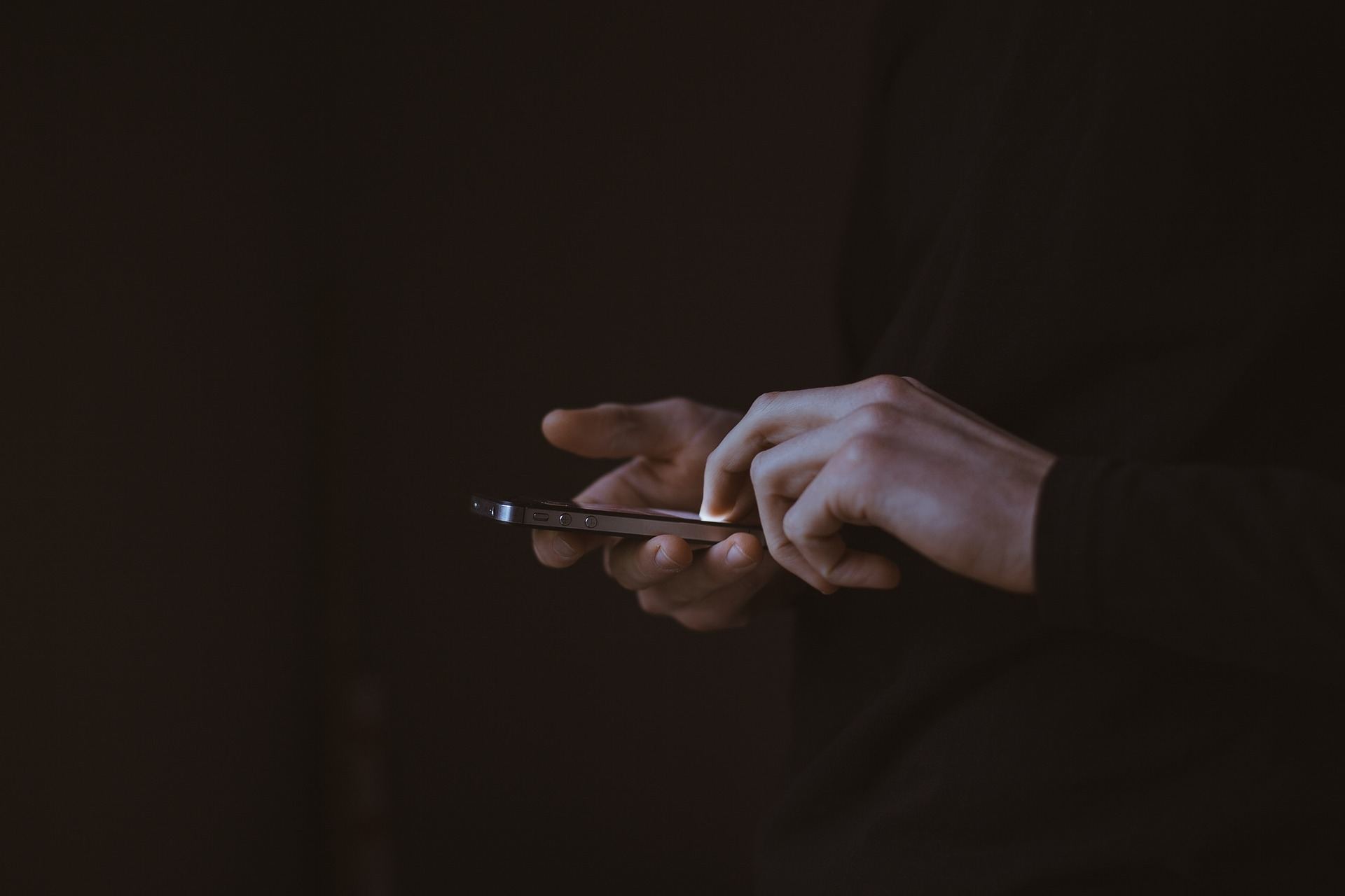 a person holding a cell phone in their hands