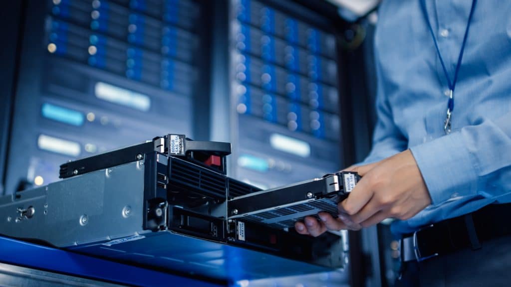 technician replacing hard drive in a high-tech data center for optimal server performance.