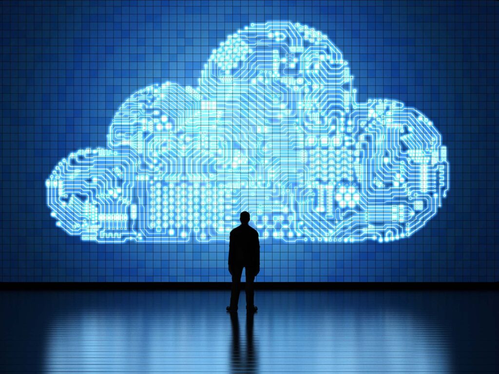 silhouetted figure reflects on luminous cloud technology and its impact on the digital future.