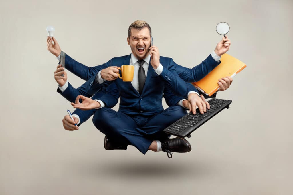 multitasking businessman in a suit, juggling a mug, magnifying glass, papers, and phone.