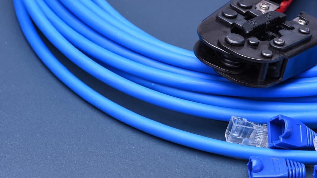 blue ethernet cables and a crimper tool for diy networking installations and repairs.